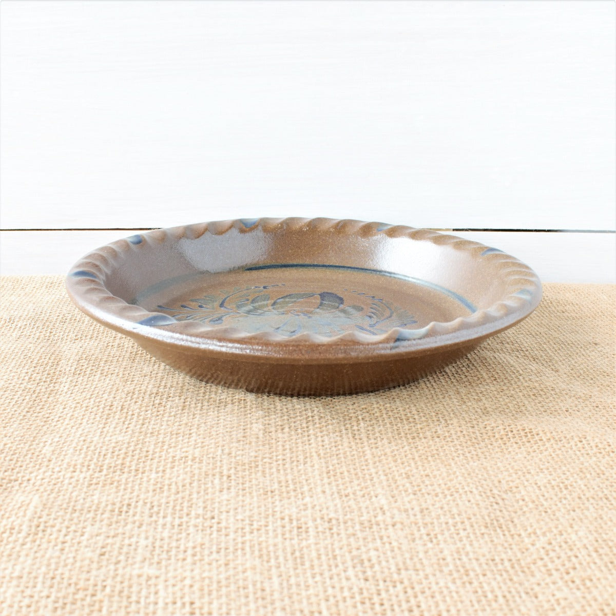 Rowe Pottery handmade stoneware pie plate with Provincial pattern low angle view