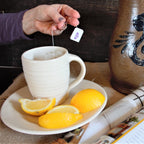 Rowe Pottery hand thrown farmhouse white ridges mug with tea on white ridges plate with lemons